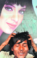 A pilgrim enjoys a free hair massage at a shop set up in the Mahakumbh area in Allahabad. Tribune photo: Mukesh Aggarwal