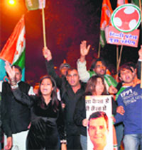 Congress supporters celebrate outside the AICC headquarters in New Delhi on Saturday. Tribune photo