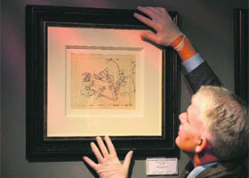 Fine art and antiques consultant Duncan Phillips hangs a never-before-seen original artwork pencil drawing from the 1937 Walt Disney Snow White and the Seven Dwarfs film at the Tatton Park fine arts and antiques fair at Tatton Park in Knutsford, north-west England. The drawing is from the collection of a well-known storyboard artist from the 1930s and 1940s and is on sale at a gallery in Derbyshire