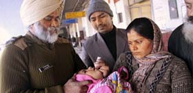 A CRPF official administers polio drops to a child at the railway station in Jalandhar on Sunday.
