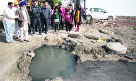Overflowing sewage coming out of uncovered manholes at Tara Singh Avenue in Jalandhar.