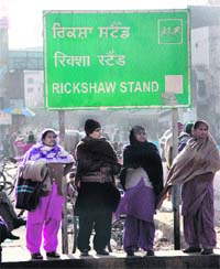 Women wait for rickshaws at the railway station as chilly winds blow in Jalandhar on Sunday.