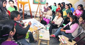 An artist paints a canvas during a workshop at BD Arya Girls College in Jalandhar Cantt.