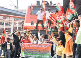 Stopped in its tracks: Samajwadi Party workers stop a train during a demonstration against the hike in diesel prices in Bhubaneswar on Sunday