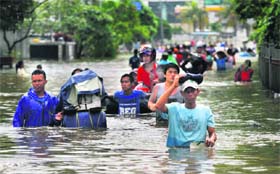 Flood-struck: People wade through a flooded street in Jakarta, Indonesia, on Sunday