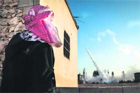 A rebel watches a rocket launch in Aleppo, Syria