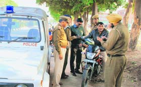 Policemen with his bike at the crime spot on the road dividing Sectors 14 and 12 in Panchkula on Monday.