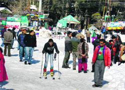 Tourists enjoy skiing on the snow-covered Mall Road in Manali on Monday. Photo: MC Thakur