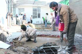 MC workers demolish a portion of the double-storeyed building at the Gian Singh Rarewala market in Ludhiana on Monday