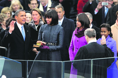 US President Barack Obama is sworn in during the public ceremony by Supreme Court Chief Justice John Roberts as First Lady Michelle Obama and daughters Sasha and Malia look on during the 57th presidential inauguration on the West Front of the US Capitol building in Washington on Monday