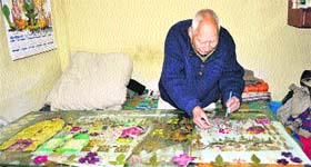 Krishan Paruthi busy making images on glass with dried flowers and leaves