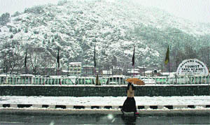 A woman walks on a roadside in Srinagar on Tuesday. 