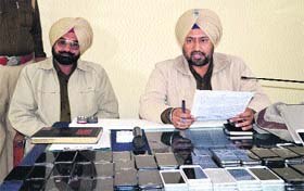 Police personnel with the recovered iPhones and iPads in Ludhiana