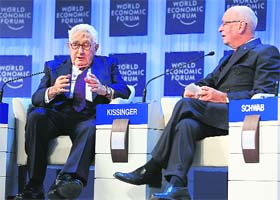 Henry Kissinger, chairman of Kissinger Associates, talks to WEF founder Klaus Schwab at the annual meeting of the World Economic Forum in Davos on Thursday