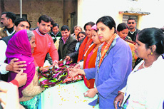 Women social activists distribute blankets to poor women at the Tibdi colony in Haridwar on Thursday. 