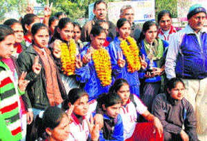 Footballers Monika, Nirmala and Hema (standing in garlands) get a warm welcome on their arrival at Sonepat railway station. 