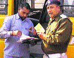 A police official checks documents of a school bus in Kurukshetra. 