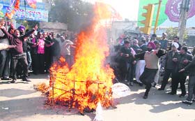 Members of the BJP burn an effigy of Union Home Minister Sushil Kumar Shinde and protest against his remarks against the RSS in Jalandhar on Thursday