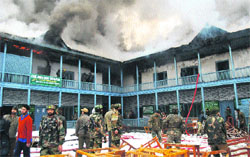 Smoke billows out from the school building, which was partially damaged in a fire at Baramulla on Thursday. A tribune photograph