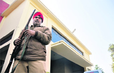 A police personnel stands guard outside the principal's office in Ludhiana on Thursday. 