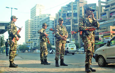 Security personnel stand guard at Connaught Place on the eve of 64th Republic Day parade in New Delhi on Friday. 