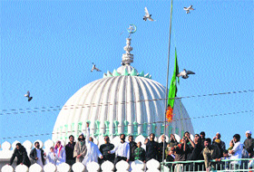 Devotees participate in the flag-hoisting ceremony during the Eid Milad-ul-Nabi celebrations at a mosque in Jammu on Friday. 