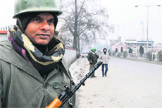 A securityman stands guard at a checkpoint in Srinagar on Friday.