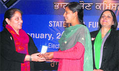 Chief Electoral Officer Kusumjit Sidhu gives a voter ID card to student in Jalandhar on Friday. A Tribune photograph