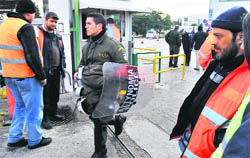 A riot policeman (C) is watched by striking metro workers at Athens metro depot on Friday.  AFP