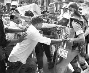 Policemen try to stop pro-Telanagana protesters in Hyderabad on Sunday. 