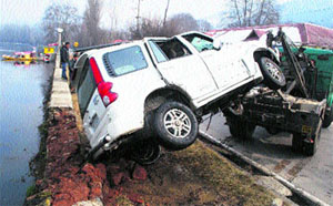 A crane pulls a vehicle out of the Dal Lake after an accident in Srinagar. A group of people had a narrow escape when their vehicle plunged into the lake as its driver lost control after hitting the parapet of the boulevard.