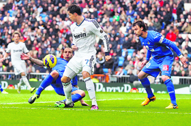 Cristiano Ronaldo fights for the ball with two Getafe defenders.