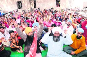 Activists of the All-India Trade Union Confederation hold a protest outside the Assistant Labour Commissioner Office in Amritsar on Monday