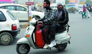 Two youths take an LPG cylinder on scooter unmindful of the risks involved. 