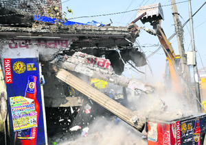 A JCB machine demolishes an illegal structure at National Highway 21 in Kharar on Monday.