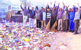 Congress councillor Pardeep Singh Rai and residents use brooms to clean a road at Babu Labh Singh Nagar in Jalandhar on Monday