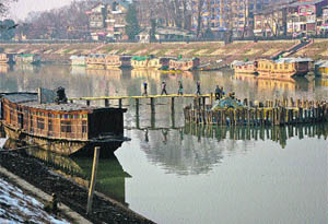 Cement being carried as work on the construction of a bridge is on in Srinagar.