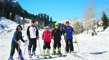 Skiers enjoy skiing on the snow-covered slopes of the Solang valley.  