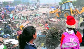 An earthmoving machine demolishes illegal structures at Pocket No. 8 in Mani Majra, Chandigarh.