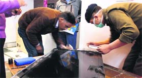 Police officials take finger prints from the house where a dacoity took place in the Raipur area of Dehradun on Thursday.