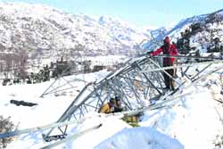 Power Development Department workers repair a transmission tower in Poonch.