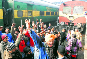 Passengers stop the Amritsar-Dera Baba Nanak passenger train and raise slogans at the railway station in Amritsar on Friday.