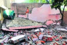 An Estate office employee demolishes an illegal structure at Sector 27, Chandigarh, on Friday.