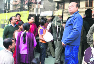 Customers wait outside a business house where income tax raid was conducted in Jalandhar on Friday.