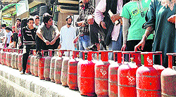 People wait for their turn in a queue to buy LPG cylinder in Srinagar on Friday
