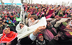 Devotees raise their arms upon seeing a relic of Prophet Mohammad during special prayers at Hazratbal shrine in Srinagar on Friday