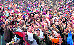 People react when a priest (inside photo) shows a relic of Prophet Mohammed at the Hazratbal Shrine in Srinagar on Friday