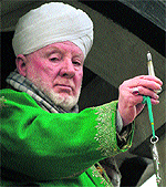 A cleric displays a holy relic, believed to contain a hair from the beard of Prophet Muhammed; and (below) devotees react on seeing it