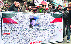 Leaders and activists of JKLF hold a signed banner during their signature campaign in Srinagar on Friday
