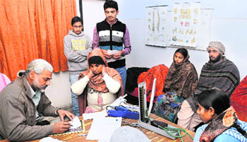 Dr Ashwani (top) with his patients at the Primary Health Centre at Lehra Mohabbat